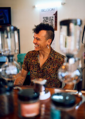 latino mid adult barista or bartender in a coffeehouse smiling happy behind a counter