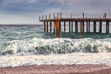 Storm in the Mediterranean Sea, Turkey, strong waves near the old wooden pier - 553626604