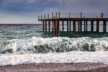 Storm in the Mediterranean Sea, Turkey, strong waves near the old wooden pier - 553626624