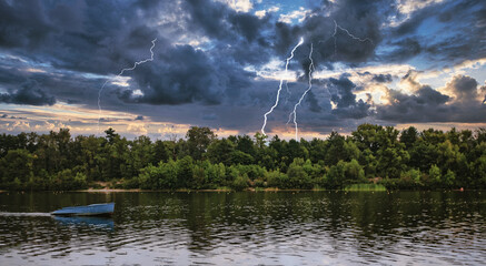 landscape empty boat on a forest lake-river under thunderclouds with lightning - 553626631