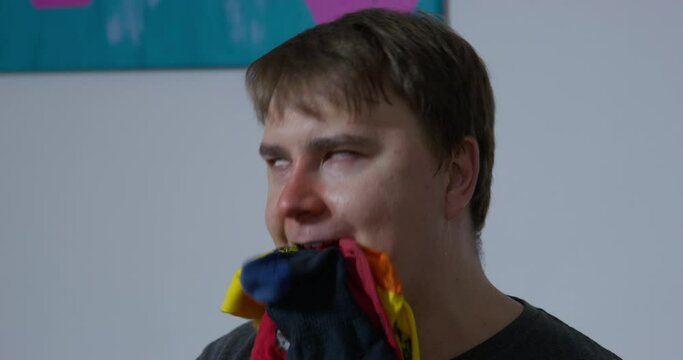 Man imagines himself dog eating dirty socks sitting in room. Brown-haired adult enjoys relaxing and chewing clothes forgetting about everything