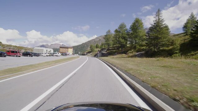 Driving on the Simplon Pass in Switzerland. The alpine landsacape filmed from the cars point of view. The Simplonpass is a famous pass road in the swiss alps. Views of a beautiful mountain panorama.