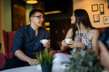 young man and woman happy couple having cup of coffee at home or cafe
