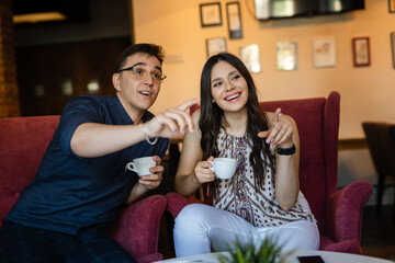 young man and woman happy couple having cup of coffee at home or cafe