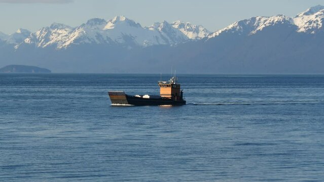 Canada inside passage,, Icy Strait Point Inian Island, Working troller boat sailing by with Mountains in the background