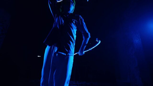 Light LED dance show. Impressive dance of a young guy with decarnation knives, glowing with LED flashlights
