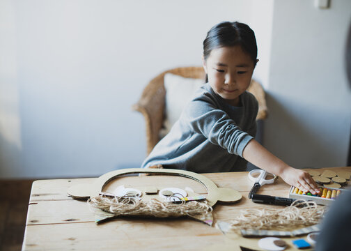 鬼のお面をテーブルの上で工作で作る子供