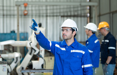 Group of engineers are manipulating a welding robot hand. By combining welding manipulation with a...