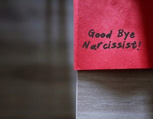 Red sticky note with text written GOOD BYE NARCISSIST, concept of stay away from narcissist who obsess too much in themselves and lack of empathy