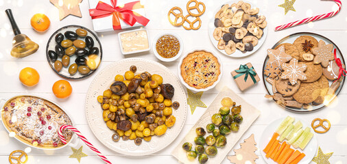 Different tasty dishes for Christmas dinner on white wooden background