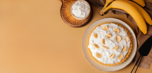Plate with tasty banana cake on beige background with space for text