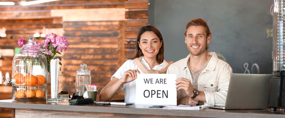 Happy young business owners in their new cafe