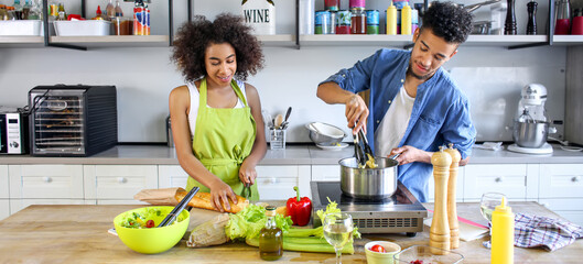 Young African-American couple cooking together in kitchen