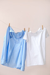 Clothes hanging on rope against color background