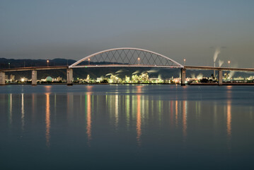 日没直後のアーチ橋と工場夜景
