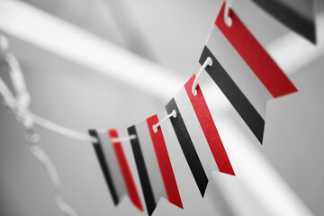 A garland of Yemen national flags on an abstract blurred background