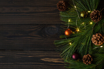 Composition with decorated Christmas tree on dark rustic wooden background with copy space for text. Christmas mock-up or greeting card. Top view.