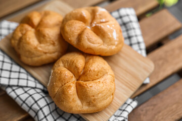 Kaiser rolls on wooden board, closeup