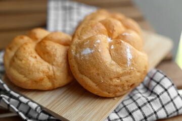 Kaiser rolls on wooden board, closeup