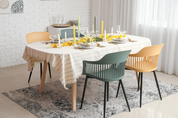 Festive table setting with floral decor in light room interior