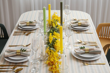 Beautiful dinnerware, candles and floral decor on served table