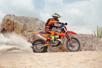 Young man practice riding dirt motorcycle. Splashing sand © Artur Didyk