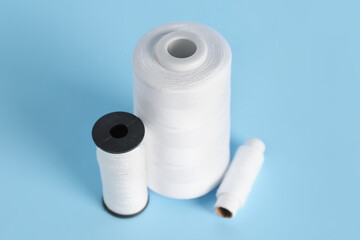 White thread spools on color background