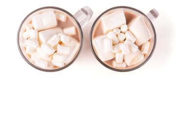 Two transparent glass mugs with hot cocoa drink and marshmallow on a white insulated background. View from above. Space for text. Template, design.