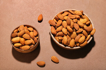 Bowls of almonds on brown background