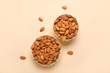 Bowls of almonds on beige background
