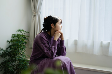 窓の外を眺める若い日本人女性