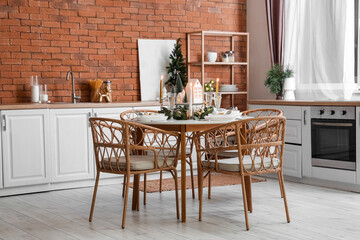 Interior of kitchen with dining table, candle holders and Christmas trees