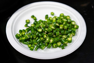 Green pepper cubes in white plate.