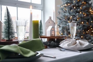 Christmas table setting with candle holders and fir branches in dining room, closeup