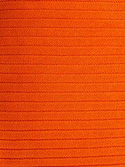 Orange textured fabric background. Bright colorful textile background. Close-up of the surface of...