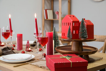 Table setting with candles and Christmas trees in dining room, closeup