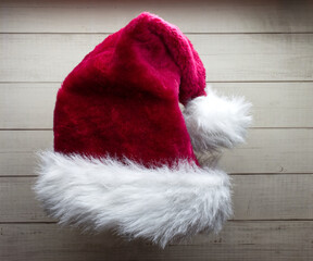 Obraz na płótnie Canvas Red Santa Claus hat isolated on wooden background.