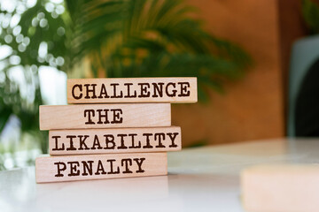 Wooden blocks with words 'CHALLENGE THE LIKABILITY PENALTY'.