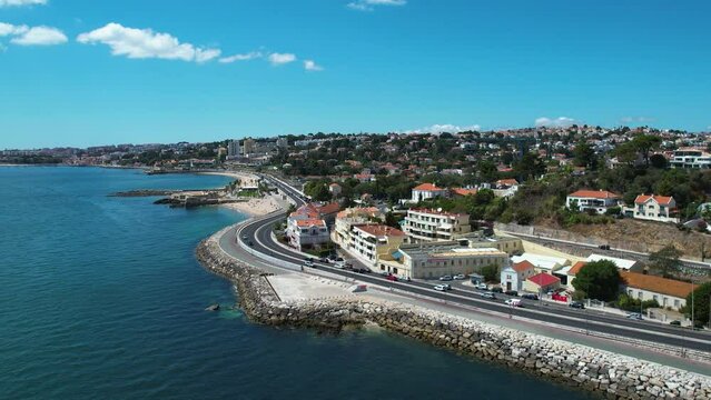 Aerial overview of traffic on road N6, sunny in Caxias, Lisbon, Portugal - circling, drone shot
