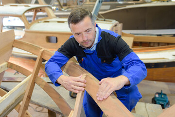Fototapeta na wymiar a man is making wooden boat