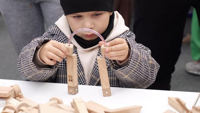 The boy plays a wooden constructor