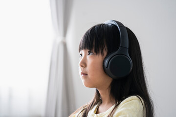 ヘッドフォンをつけた日本人小学生の女の子