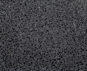 Gray terrazzo stone flooring with dark grey flecks, viewed from above. Abstract full frame textured background, top view.