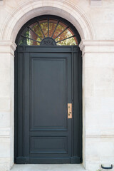Fototapeta na wymiar grey wooden arch door of street restored house entrance facade classic gate