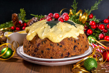 Traditional Christmas english pudding dessert. Homemade fruit pudding, with custard creme anglaise. Sweet aromatic fruit cake for Christmas, New Year dinner on cozy decorated background