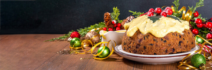 Traditional Christmas english pudding dessert. Homemade fruit pudding, with custard creme anglaise. Sweet aromatic fruit cake for Christmas, New Year dinner on cozy decorated background
