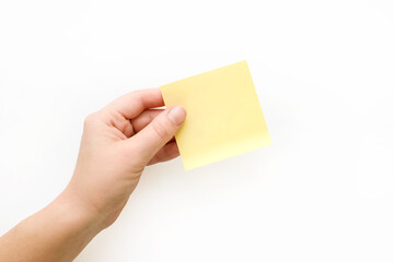 Yellow note paper in hand. Blank sticker for notes with place for your text