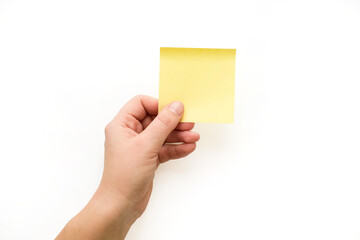 Yellow note paper in hand. Blank sticker for notes with place for your text