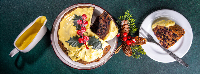 Traditional Christmas english pudding dessert. Homemade fruit pudding, with custard creme anglaise. Sweet aromatic fruit cake for Christmas, New Year dinner on cozy decorated background