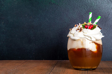 Christmas pudding latte. Sweet coffee drink with whipped cream, vanilla custard creme anglaise, fruit pudding syrup, styled like traditional Christmas english fruit pudding, on cozy decorated backgrou